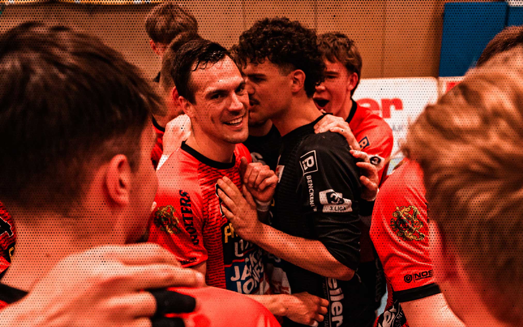 a group of men in sports uniforms hugging